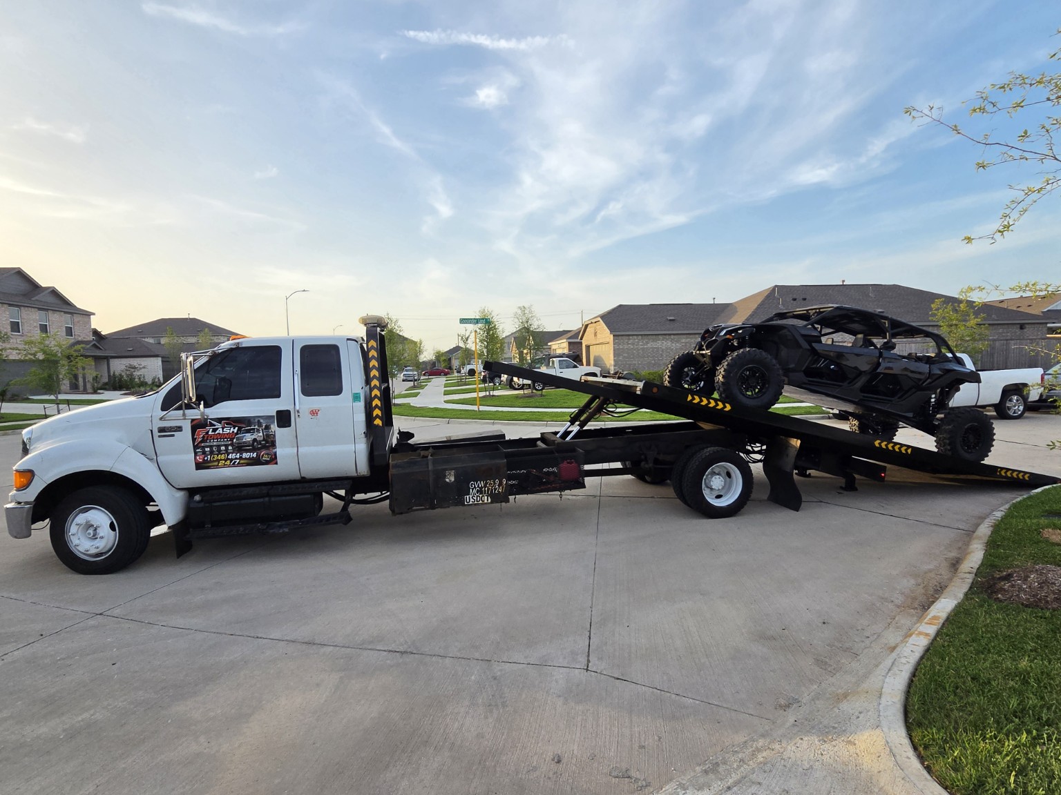 Flash Towing flatbed truck transporting two vehicles in daylight in Houston